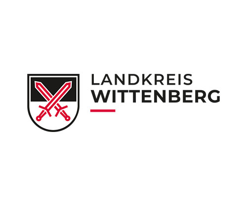 Landkreis Wittenberg logo: shield with two crossed swords and the text LANDKREIS WITTENBERG with a red underline as a graphic mark.