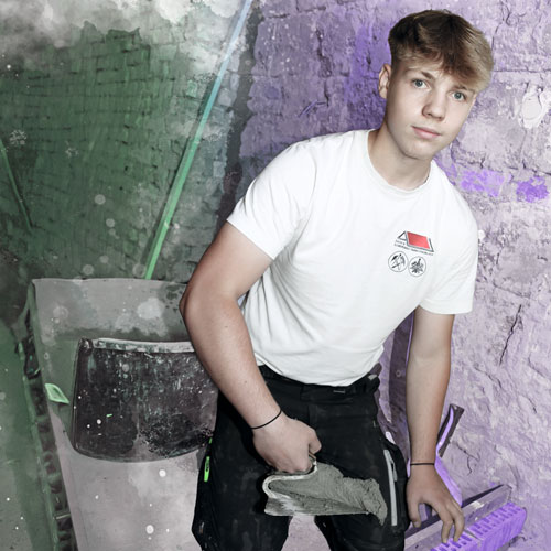 Young man in a white t-shirt holding a trowel with wet plaster in an unfinished construction area with green and purple walls.